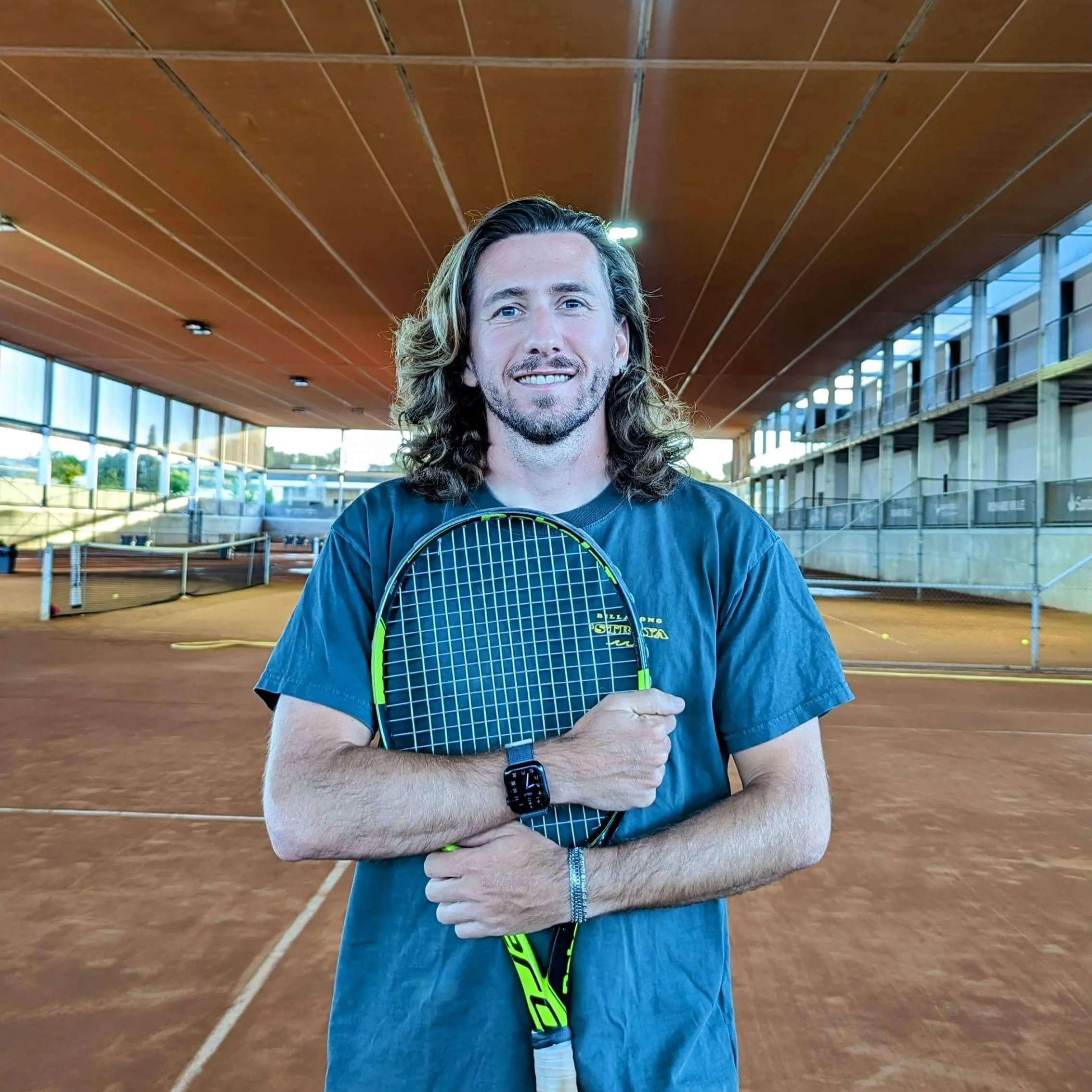 Photo of the Evolve high performance tennis coach Riccardo Leone holding a racket on a tennis court, reflecting our dedication to science based tennis training and guiding tennis player development.