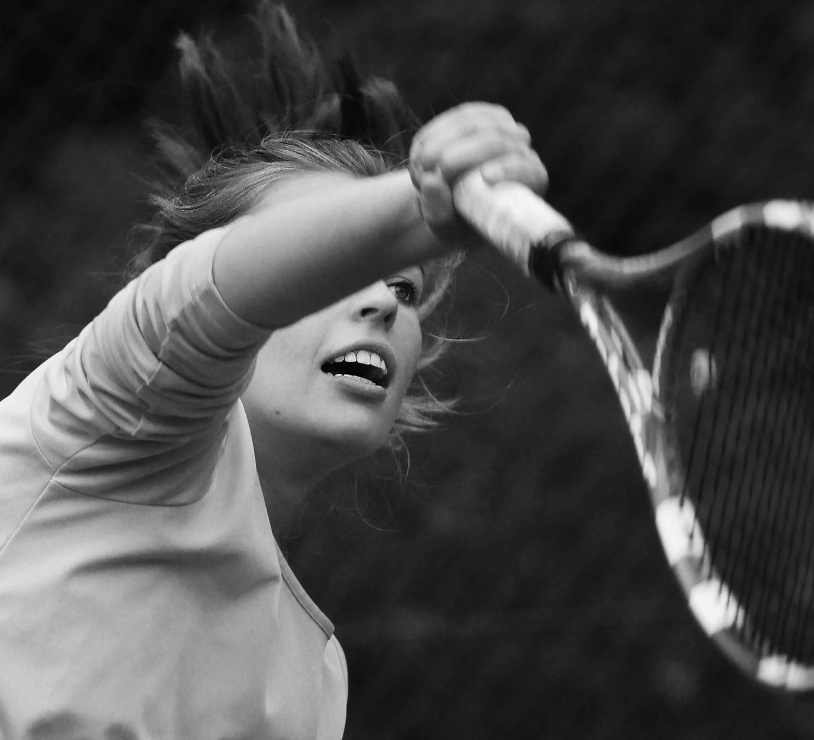 Intense close-up of a female tennis player in action, representing the focus and tennis mental training emphasized in our online tennis program and comprehensive tennis development plan.